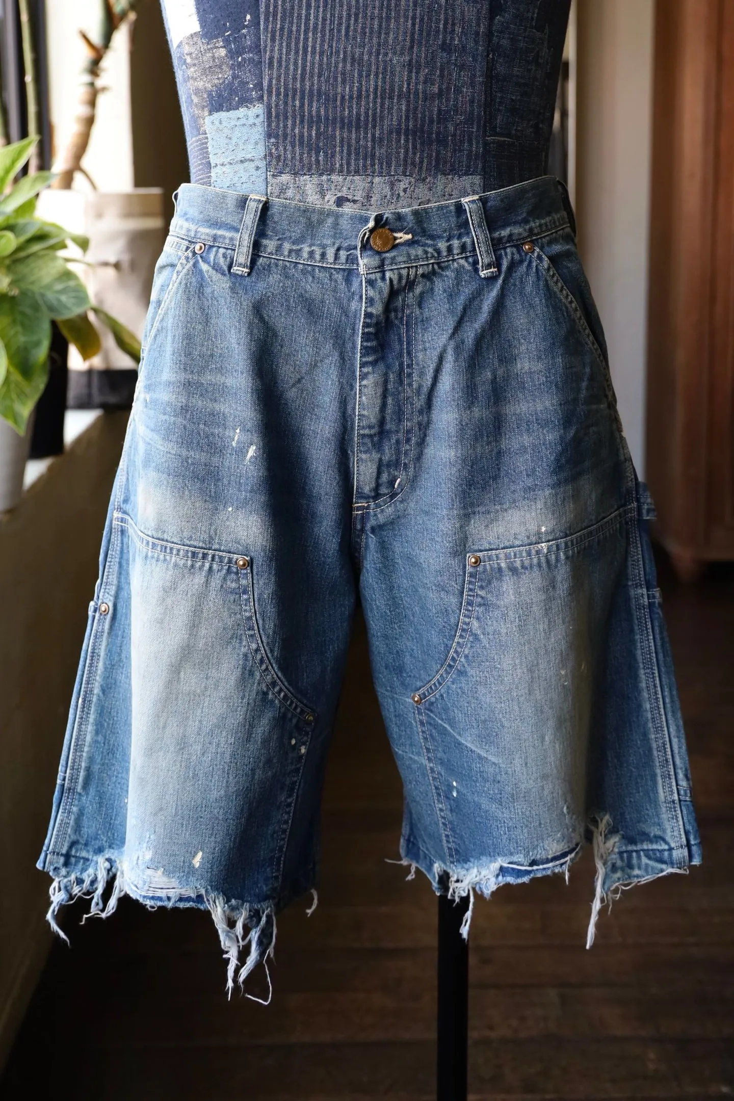 SAINT Mxxxxxx DOUBLE KNEE SHORTS/BLU Knee patches splashed with ink and water-splashed denim shorts. Denim blue S-XL. Custom-woven and dyed denim fabric with clear texture. Heavy-wash water-fading treatment to create local mottled fading/hole effects. Artificial distressing to simulate natural wearing marks. VINTAGE sense. Original consistent damage treatment. Hand-splashed ink and paint. Original consistent wash mark/pocket mark. Double knee patch. Rivet reinforcement. Improve functionality while enhancing design